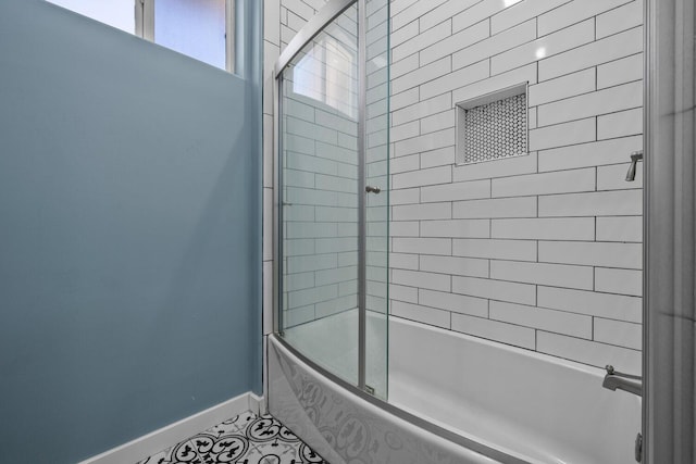 bathroom featuring tile patterned flooring and combined bath / shower with glass door