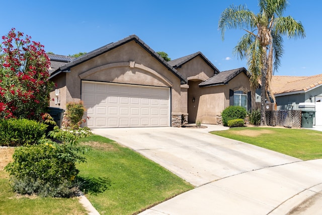 ranch-style home with stucco siding, a garage, driveway, a front yard, and a tile roof