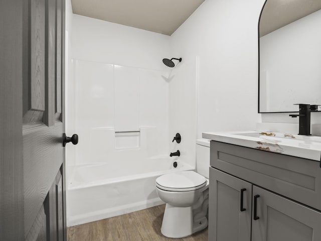 full bathroom featuring vanity, toilet, washtub / shower combination, and hardwood / wood-style flooring