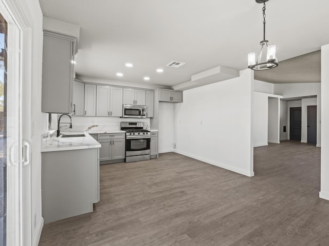 kitchen featuring appliances with stainless steel finishes, dark hardwood / wood-style floors, gray cabinetry, and sink