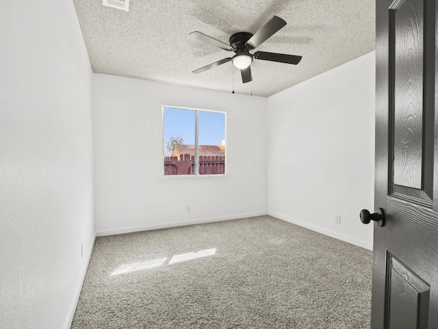 carpeted spare room featuring a textured ceiling and ceiling fan