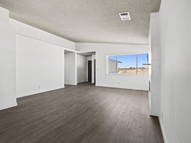 unfurnished living room featuring a textured ceiling, lofted ceiling, and dark wood-type flooring