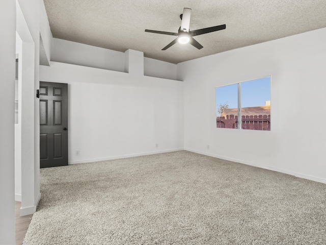 unfurnished room with ceiling fan, light carpet, and a textured ceiling