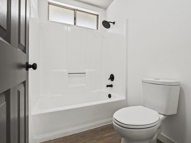 bathroom with toilet, wood-type flooring, and tub / shower combination