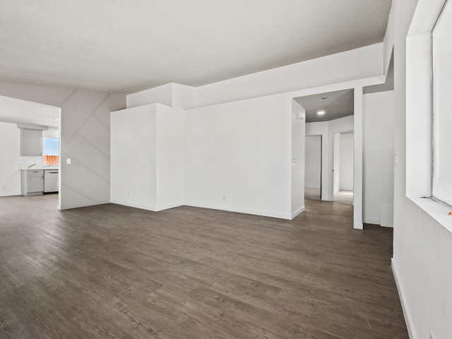 spare room with a wealth of natural light and dark wood-type flooring