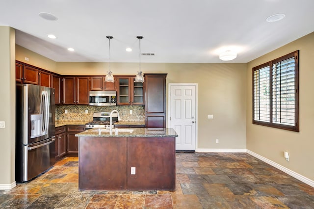 27735 Summer Grove Pl, Valencia, CA 91354 - kitchen featuring appliances with stainless steel finishes, baseboards, dark stone finish flooring, stone countertops, and tasteful backsplash