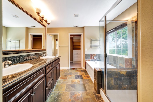 27735 Summer Grove Pl, Valencia, CA 91354 - bathroom featuring double vanity, stone finish floors, a shower stall, a bath, and baseboards