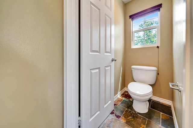 27735 Summer Grove Pl, Valencia, CA 91354 - bathroom featuring toilet, baseboards, and stone finish flooring