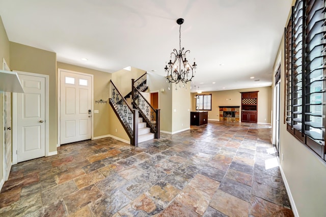 27735 Summer Grove Pl, Valencia, CA 91354 - entrance foyer featuring stone tile flooring, a chandelier, baseboards, stairway, and a fireplace