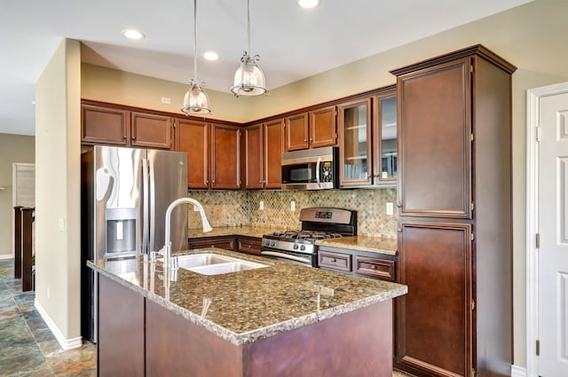 27735 Summer Grove Pl, Valencia, CA 91354 - kitchen featuring appliances with stainless steel finishes, tasteful backsplash, a sink, baseboards, and stone countertops