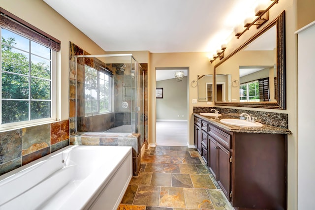 27735 Summer Grove Pl, Valencia, CA 91354 - bathroom featuring stone tile flooring, double vanity, a bath, a stall shower, and baseboards