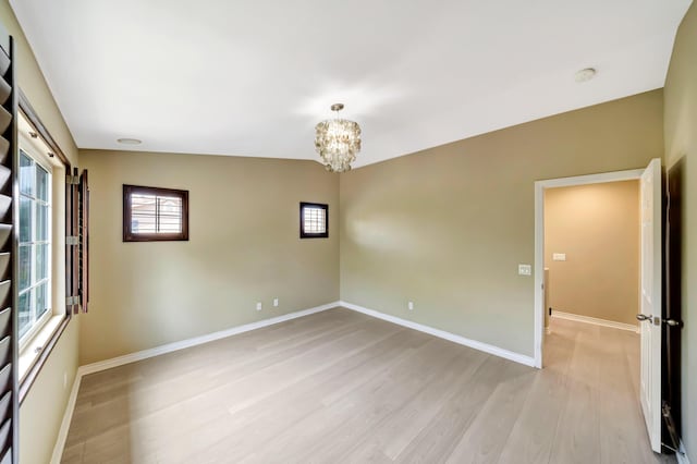 27735 Summer Grove Pl, Valencia, CA 91354 - empty room with light wood-style flooring, a chandelier, baseboards, and a smoke detector