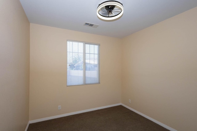 unfurnished room featuring dark carpet