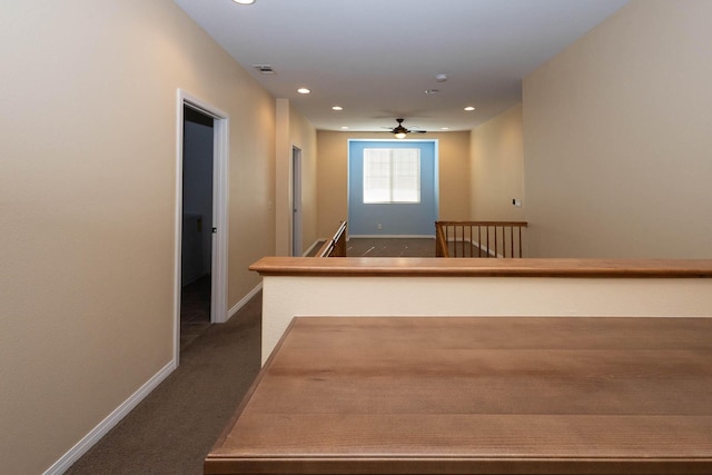 hall featuring dark colored carpet