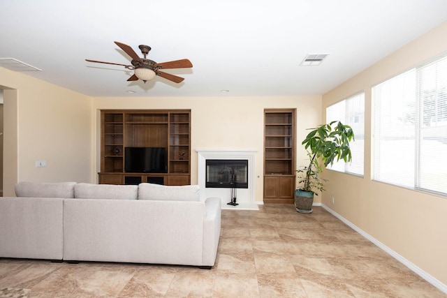 living room featuring built in shelves and ceiling fan