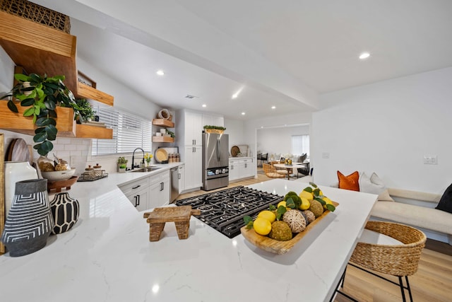 11946 Aneta St, Culver City, CA 90230 - kitchen with tasteful backsplash, open shelves, light stone countertops, a kitchen bar, and stainless steel appliances
