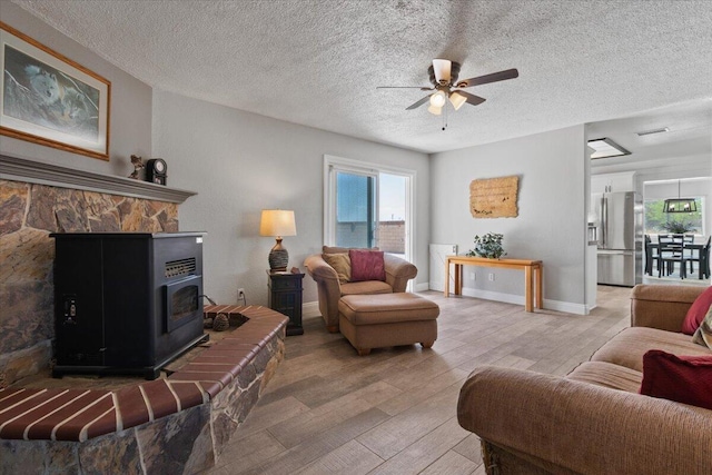 44850 E 43rd St, Lancaster, CA 93535 - living room with light wood-style floors, a ceiling fan, a textured ceiling, and a wood stove