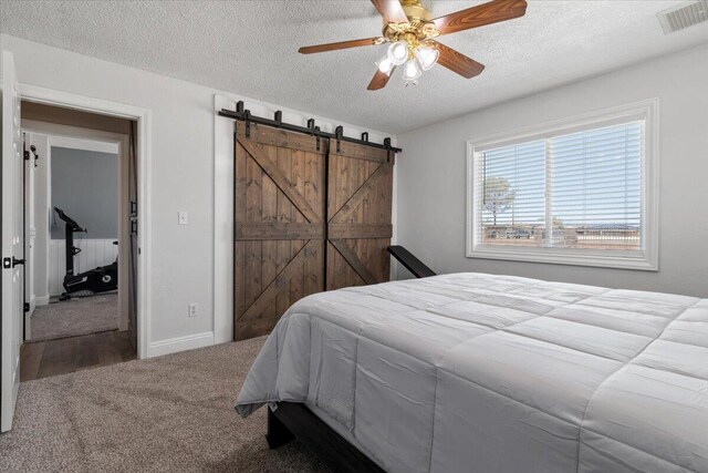 44850 E 43rd St, Lancaster, CA 93535 - bedroom featuring a textured ceiling, a barn door, carpet, ceiling fan, and baseboards