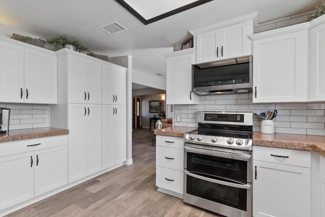 44850 E 43rd St, Lancaster, CA 93535 - kitchen featuring stainless steel appliances, light wood-style flooring, white cabinets, decorative backsplash, and a textured ceiling