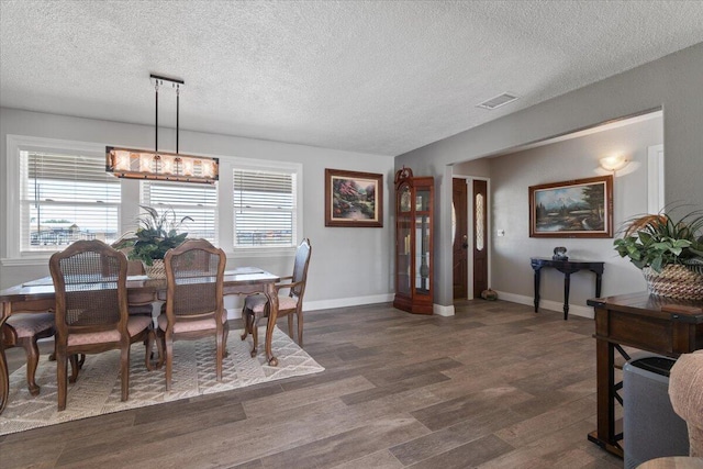44850 E 43rd St, Lancaster, CA 93535 - dining area featuring healthy amount of natural light, a textured ceiling, a chandelier, dark wood finished floors, and baseboards
