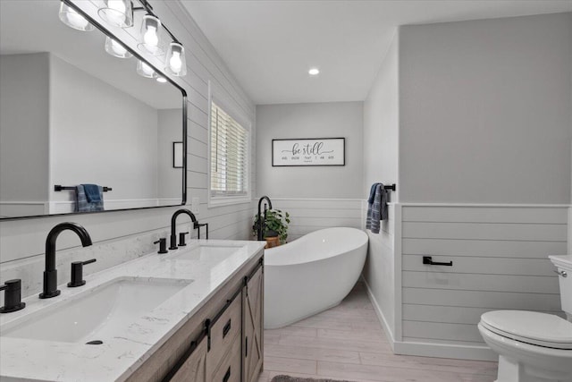 44850 E 43rd St, Lancaster, CA 93535 - full bathroom featuring wood finished floors, a freestanding bath, recessed lighting, double vanity, and toilet