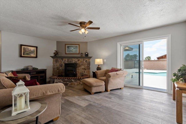 44850 E 43rd St, Lancaster, CA 93535 - living area with a ceiling fan, wood finished floors, a textured ceiling, and a fireplace
