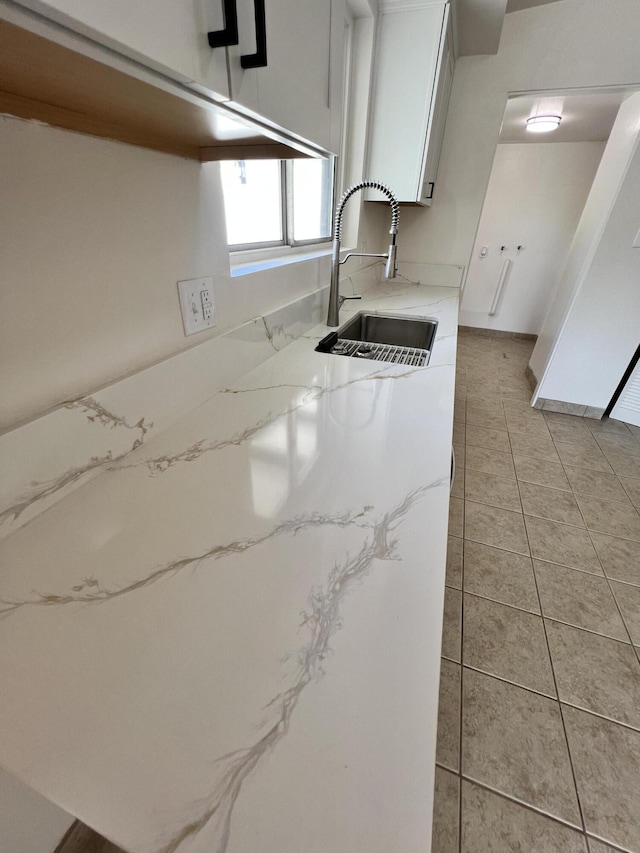 kitchen featuring white cabinetry, sink, and light tile patterned floors