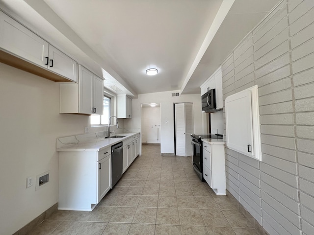 kitchen with white cabinets, light stone counters, sink, and stainless steel appliances