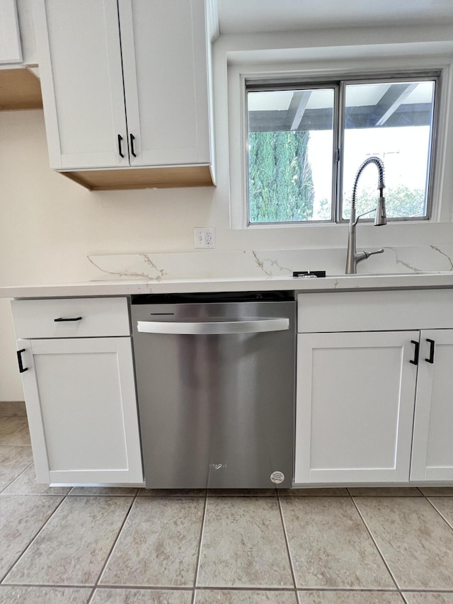 kitchen featuring light stone counters, dishwasher, and white cabinets