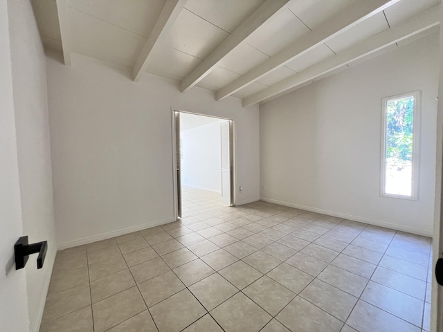 spare room with beam ceiling and light tile patterned floors