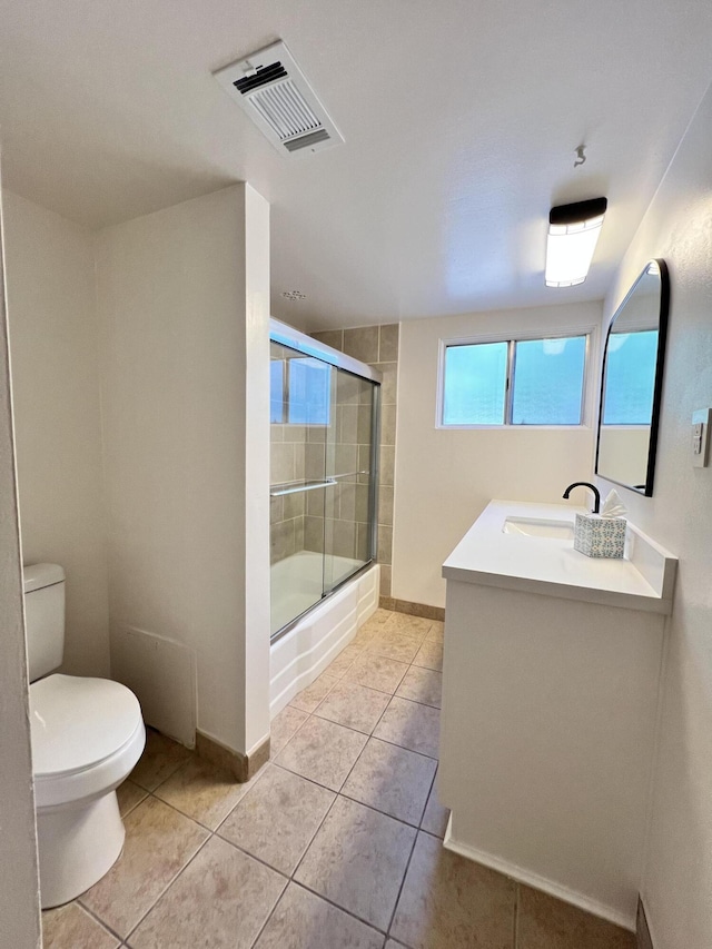 full bathroom with tile patterned flooring, vanity, toilet, and bath / shower combo with glass door