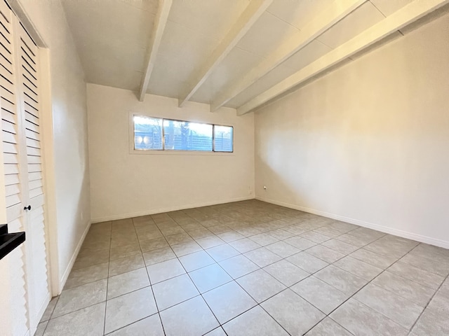 tiled spare room with lofted ceiling with beams