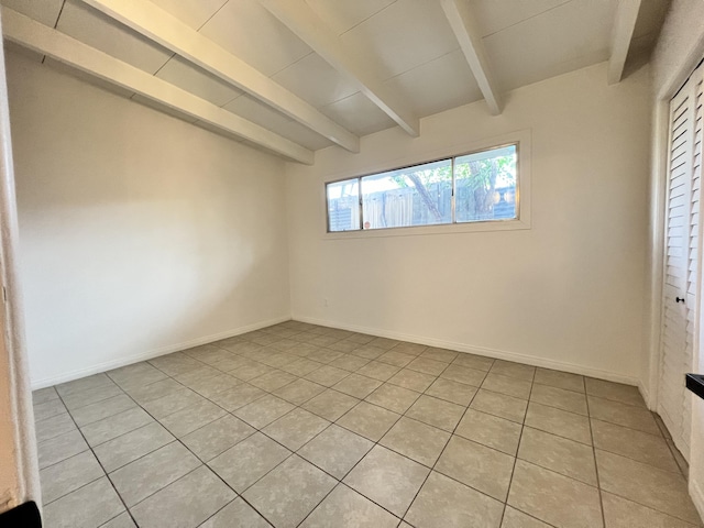 tiled empty room with beam ceiling and wooden ceiling