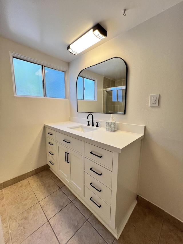 bathroom with a shower, tile patterned flooring, and vanity