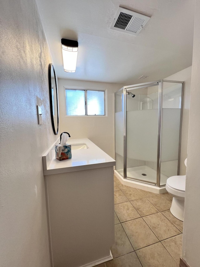 bathroom with tile patterned floors, vanity, toilet, and walk in shower