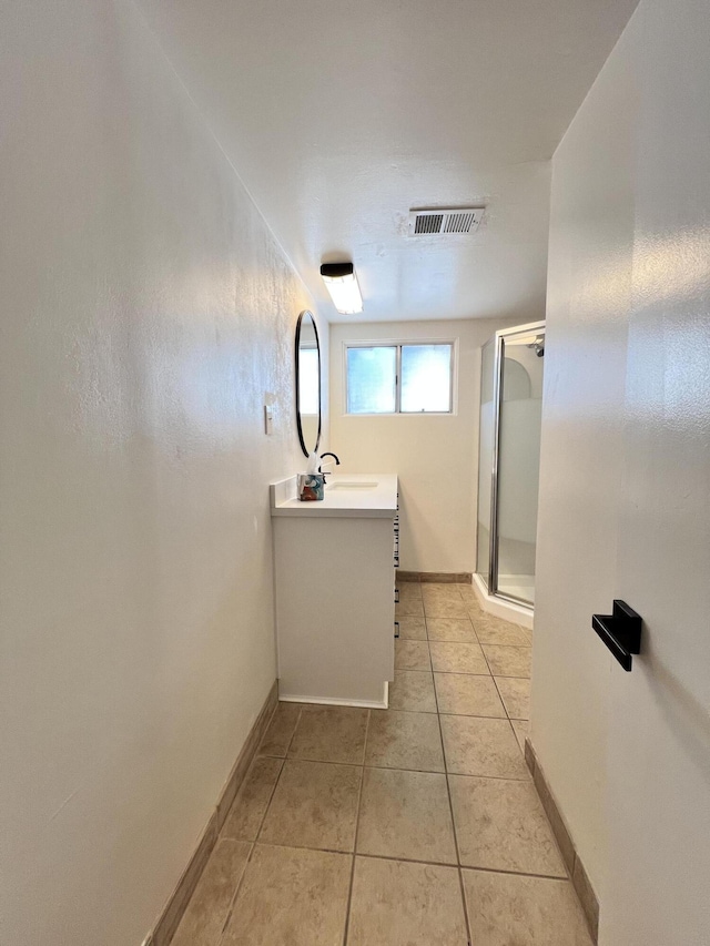 bathroom with tile patterned floors, vanity, and walk in shower