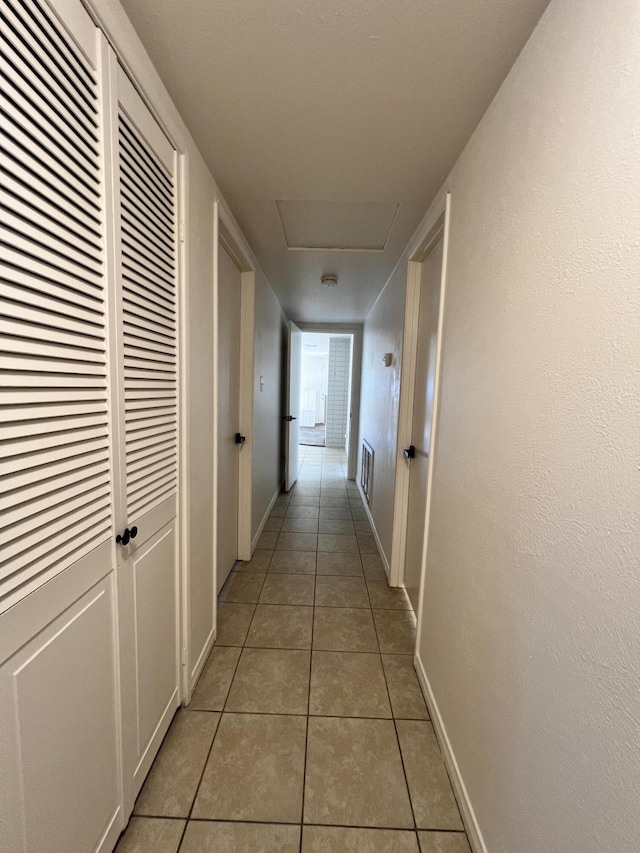 hall with light tile patterned floors