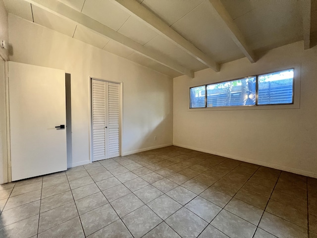 unfurnished bedroom with beam ceiling and light tile patterned flooring