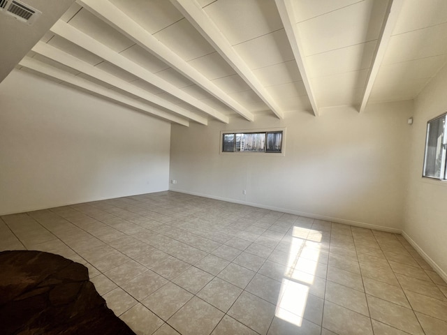 tiled empty room with beamed ceiling