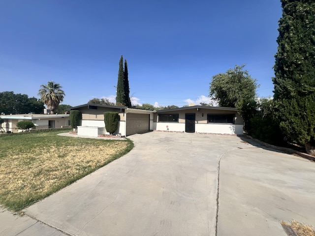 ranch-style home featuring a garage and a front lawn