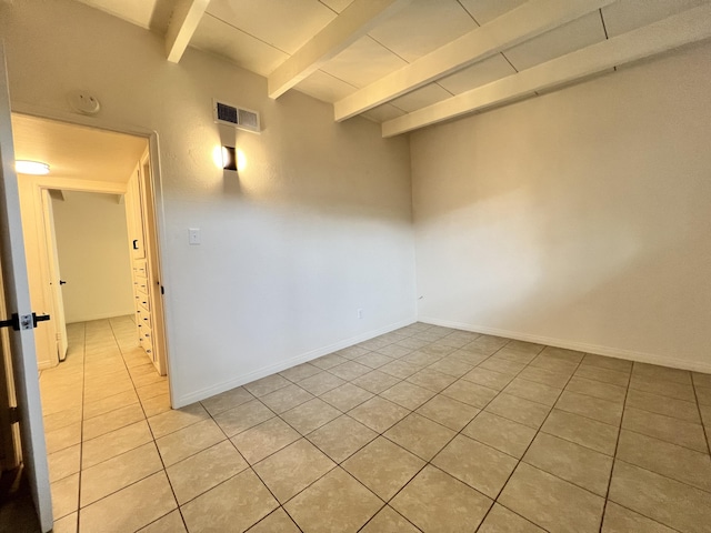 spare room with beam ceiling, light tile patterned floors, and wood ceiling