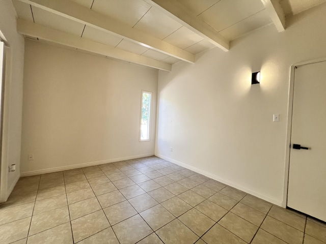 tiled spare room with beamed ceiling