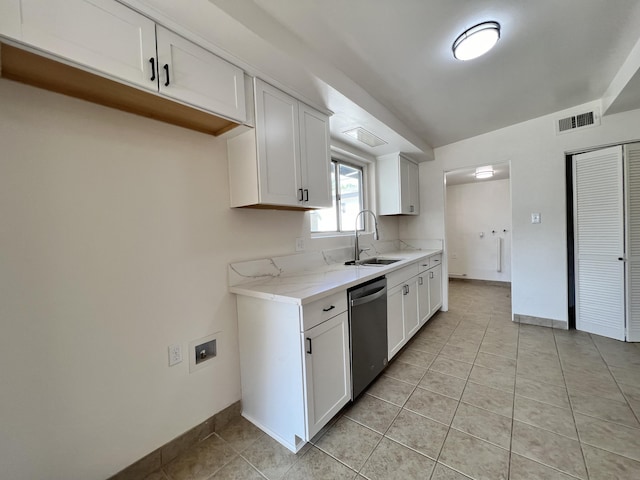 kitchen featuring dishwasher, sink, light tile patterned flooring, light stone counters, and white cabinetry