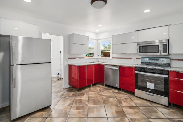 44251 Date Ave, Lancaster, CA 93534 - kitchen featuring stainless steel appliances, a sink, modern cabinets, red cabinetry, and light countertops