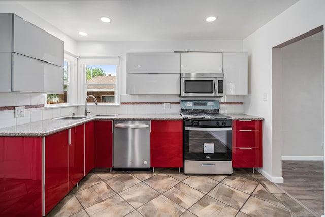 44251 Date Ave, Lancaster, CA 93534 - kitchen featuring recessed lighting, red cabinetry, modern cabinets, a sink, and appliances with stainless steel finishes