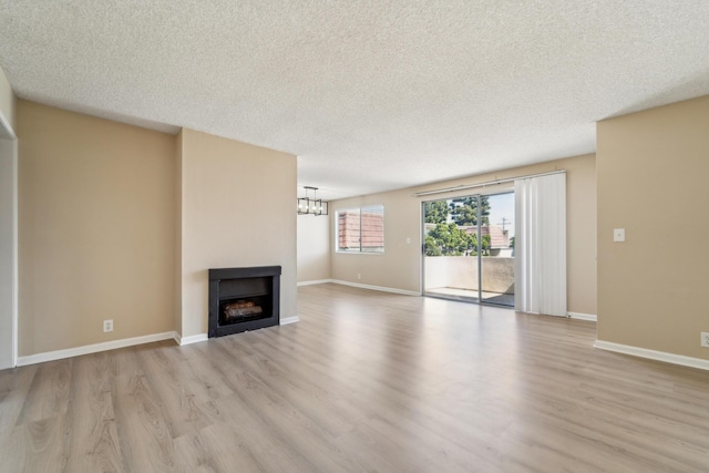 unfurnished living room featuring a fireplace, wood finished floors, and baseboards