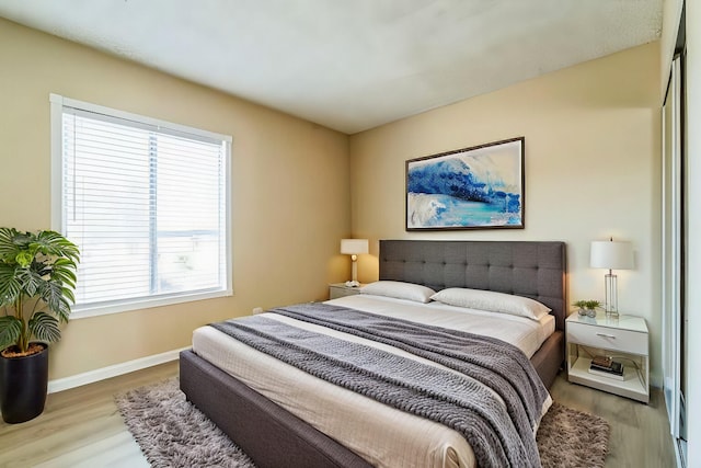 bedroom featuring baseboards and wood finished floors