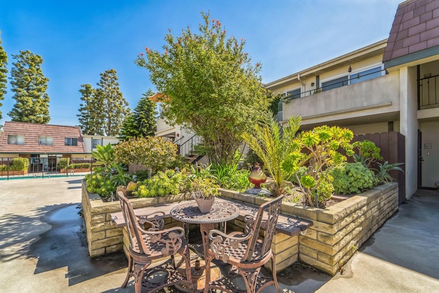 view of patio / terrace with outdoor dining area, an outdoor pool, and fence