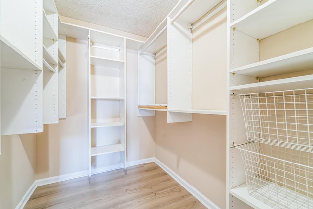 walk in closet with wood finished floors