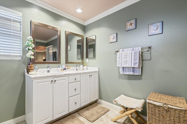 full bath with a sink, baseboards, double vanity, and crown molding